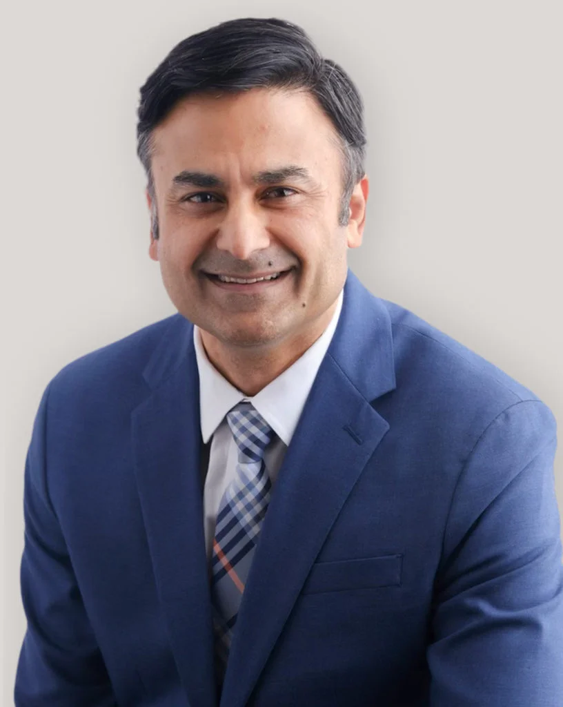 Portrait of Medical Director Dr. Hassnain Syed in a blue suit.